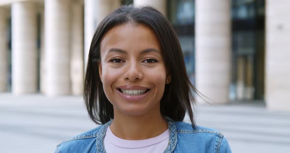 Bokeh Shot of Young African Woman Smiling Confident at City