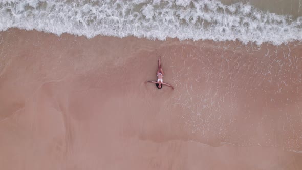 Woman In Bikini Lying In Shallow Tide On Nacpan Beach