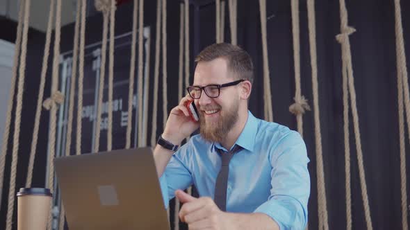 Excited Businessman in a Restaurant with a Laptop