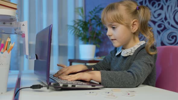 Child Girl Pupil Doing School Homework on Laptop Computer at Home with Teacher Distance Education