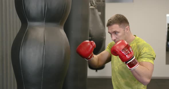 A Young Athlete Boxing a Pear in Red Boxing Gloves