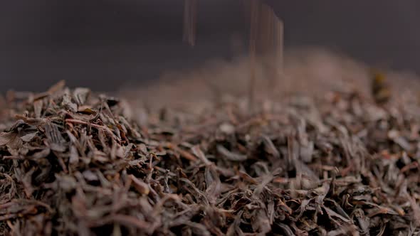 Spinning and Falling Dry Black Tea Closeup Background