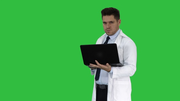Doctor Showing Results in Laptop on A Green Screen, Chroma Key.