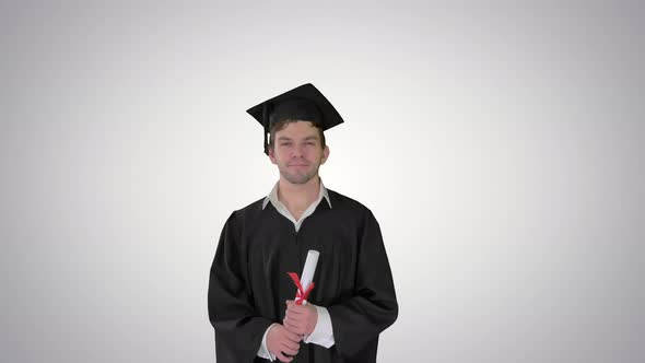 Male Graduation Student Smiling and Tossing Up His Hat Over on Gradient Background.