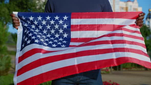 Close Up AfroAmerican Man Stands in Park with USA Flag in Summer