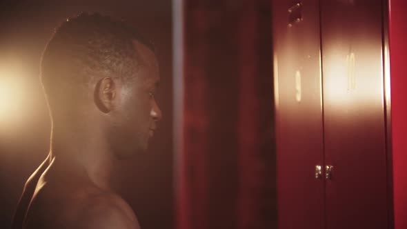 A Black Man Opening His Locker on a Key in Locker Room