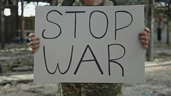 Close Up of Soldier Holding Banner with Stop War Inscription