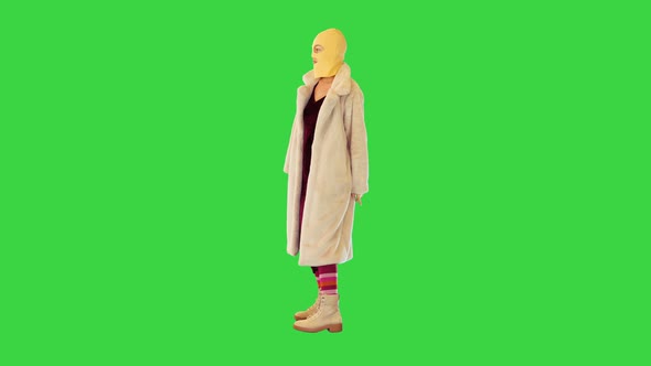 Girl in Fur Coat and Balaclava Dancing Slightly on a Green Screen Chroma Key