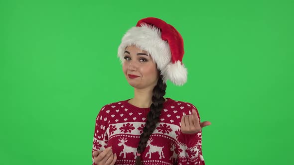 Portrait of Sweety Girl in Santa Claus Hat Is Coquettishly Showing Gesture Come Here. Green Screen