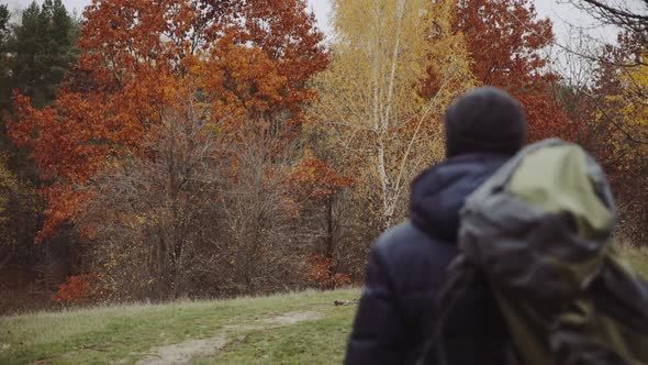 Male tourist in the forest. Young tourist with backpack walking by the forest in nature