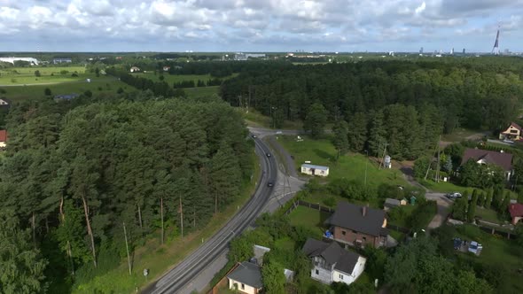 Aerial View of the Highway Going Through the Green Fields and Forests