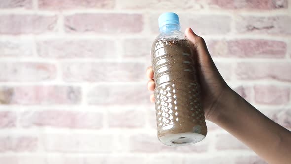 Men Holding Dirty Bottle of Water