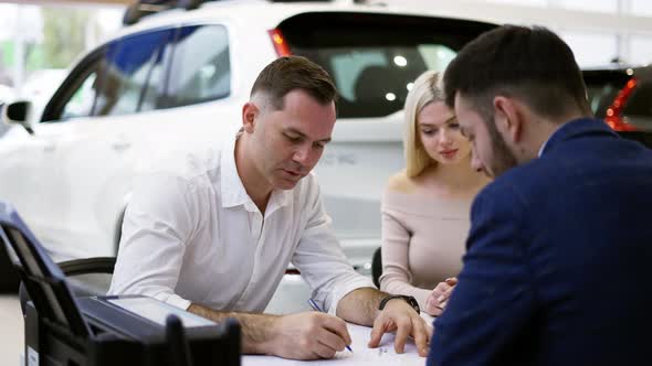 Family Purchase of a New Car Signing the Contract in the Showroom