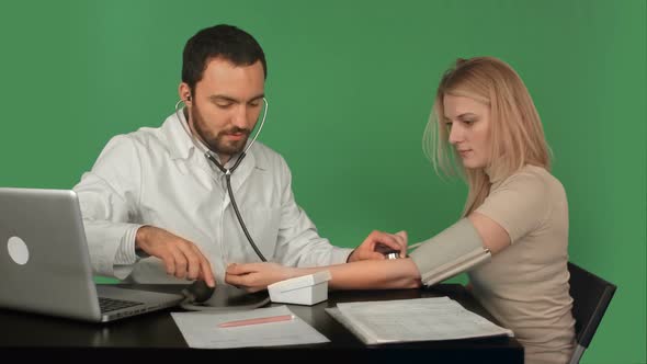 Doctor and Patient with Blood Pressure Meter in a Hospital on a Green Screen, Chroma Key