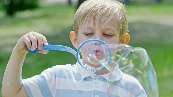 Cute Boy Blowing Bubbles Outdoor