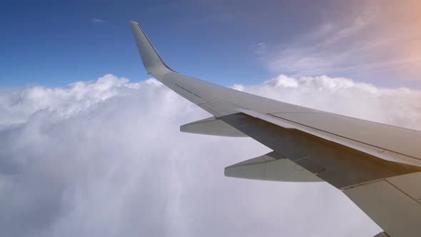 Wing of an Airplane Flying Above the Clouds