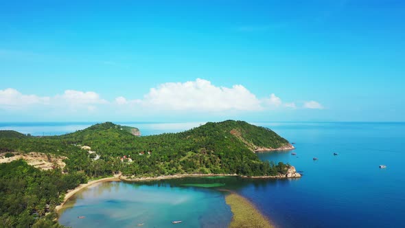 Wide angle flying copy space shot of a white sandy paradise beach and blue sea background