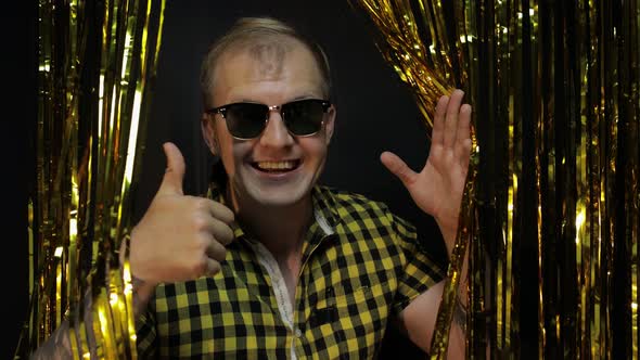 Portrait of Caucasian Man Posing on Black Background. Gold Shining Foil Strips. Party, Music, Disco