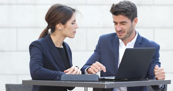 Business People Looking at Laptop Computer and Discuss