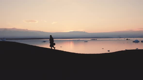 Silhouette Of Man Walking Through Icelandic Landscape