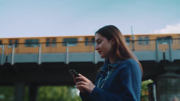 Young woman holds her phone and she is looking for directions