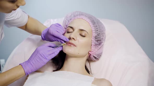 Beautiful woman is lying on a couch at a reception by a beautician.