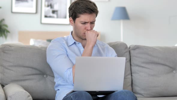 Man Coughing while Working on Laptop in Creative Office