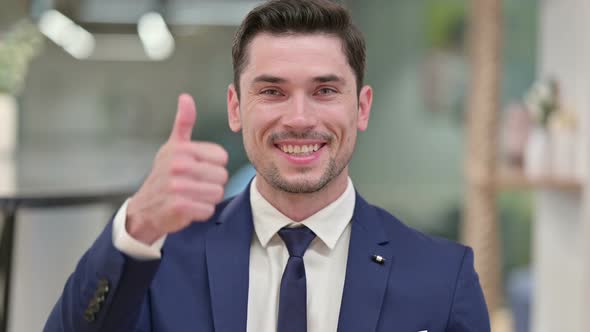 Positive Young Businessman Doing Thumbs Up 