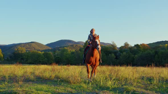 A Woman Rides a Horse at Sunset
