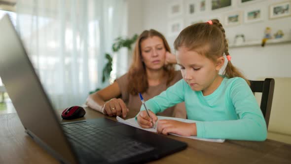 Girl Schoolgirl With A Woman Mother Does Home Lessons