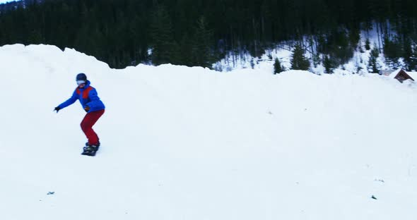 Person snowboarding on snowy mountain