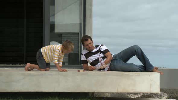 LS OF A FATHER AND SON PLAYING WITH A TOY BOAT