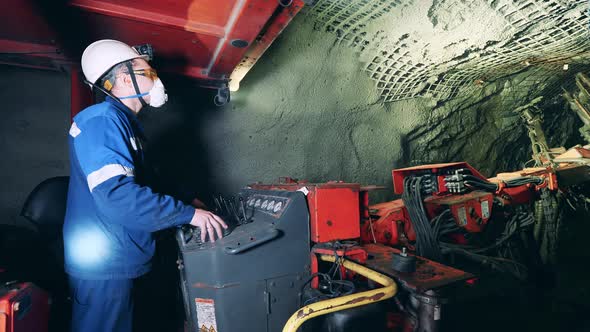 Male Worker is Managing a Boring Irrigation Machine Underground