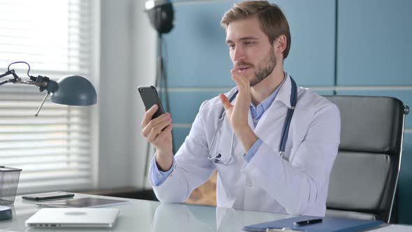 Doctor Showing Thumbs Down Sign While Using Laptop at Work