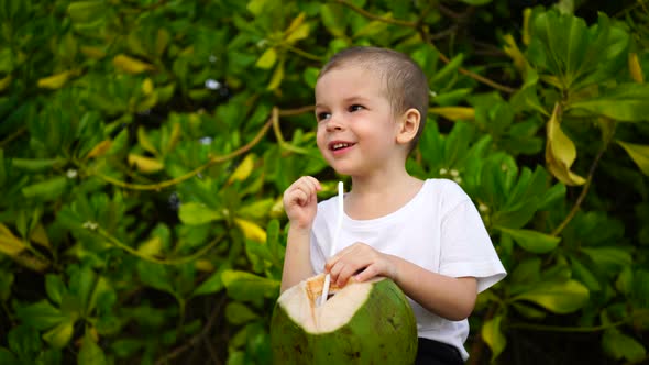 Boy of Two Years Sings Coconut Juice on the Beach.