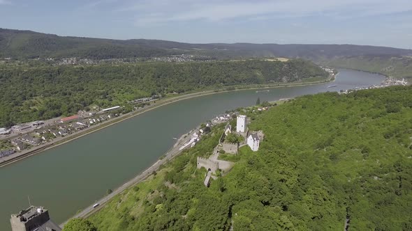 Aerial view of two castles on a mountain and a river.