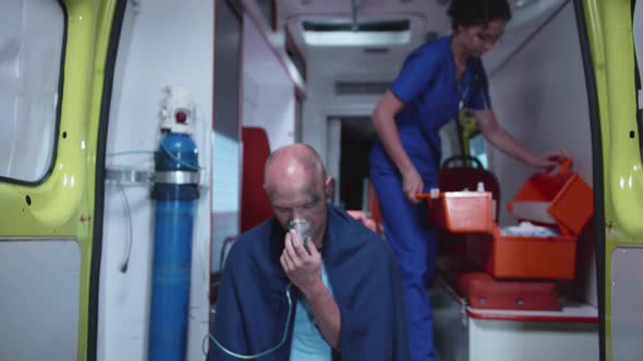 Sick Man Sit in Oxygen Mask in Ambulance Car