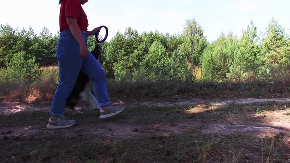 Young Woman Walking with Her Dog and About to Play with It Using a Toy