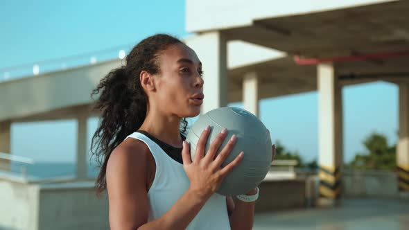 A focused african american woman doing squats outside