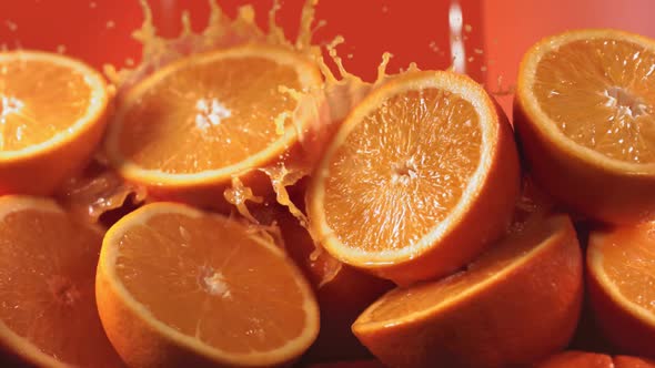 Slow Motion Shot of Orange Juice Splashing Through Orange Slices