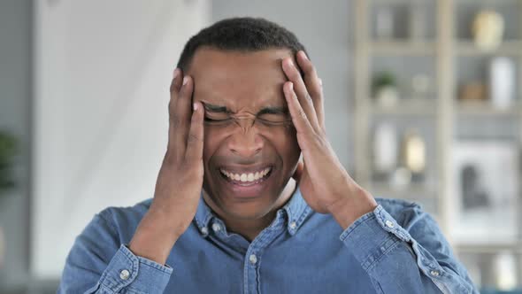 Young African Man Upset By Loss While Working in Office