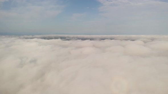 Aerial footage of flight over white puffy clouds.