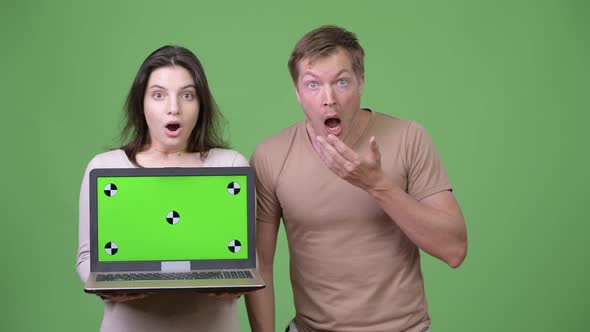 Young Couple Showing Laptop While Looking Shocked Together