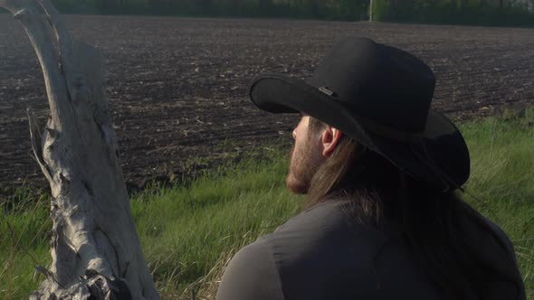 Man a Farmer in a Hat with a Red Beard and a Straw in His Mouth Looks at His Fields Has a Rest