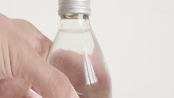 Glass bottle on white background close-up 4K video