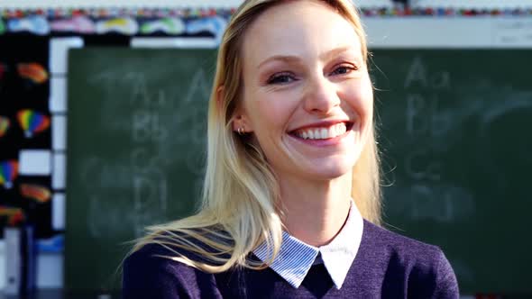 Portrait of Happy Teacher Standing in Classroom