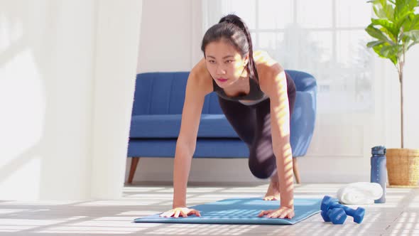 Athlete Asian young woman doing Mountain Climber on exercise mat at home