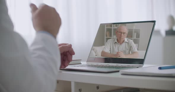 Psychologist Is Explaining To Male Elderly Patient During Online Appointment, Closeup of Doctor