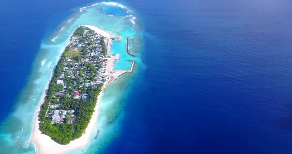 Wide aerial island view of a white sand paradise beach and aqua turquoise water background in vibran