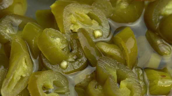 Sliced Pickled Jalapeno Peppers Rotate As Background Closeup of Pickled Chili Jalapeno Peppers